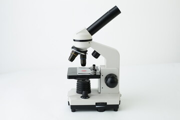 A gray and white microscope is depicted on a white background