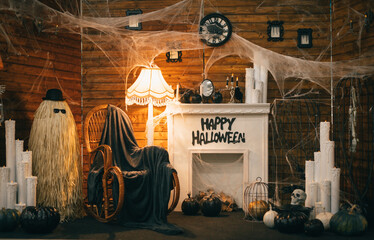 Photo of a Halloween decor with a fireplace and a rocking chair. Interior is decorated for...
