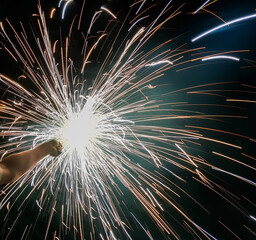hand charki, a hand firework emitting circular sparks in black background