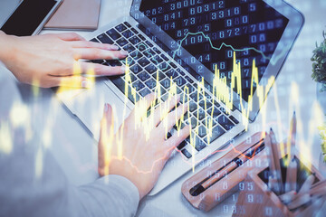 Multi exposure of woman hands typing on computer and forex chart hologram drawing. Stock market analysis concept.