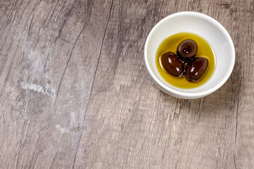 black olives with olive branch on a wooden board