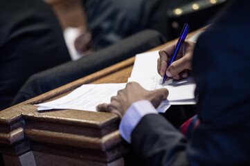 Man Writes With Pen On A Wooden Bench