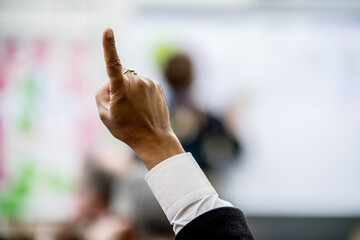 Hand raised for a Question  at a Business and Academic Conference Event