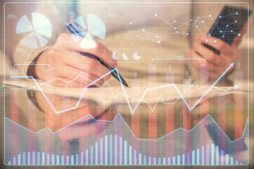 Double exposure of forex chart sketch hologram and woman holding and using a mobile device. Financial market concept.