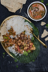 Indian eggpant curry and rice on  banana leaf with dal and papad