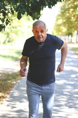 Soft focus. Toning. The gray-haired senior man is engaged in sports walking on the street. Recovery after stroke or heart attack concept.