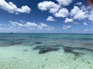 bright blue and green ocean with bright white clouds 