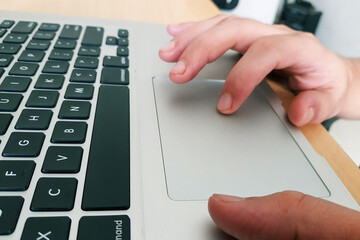 fingers operating touchpad of a laptop