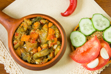 Steamed vegetables in a pan and chopped fresh vegetables on a white napkin