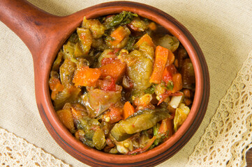 Stewed vegetables in a ceramic frying pan on a white napkin