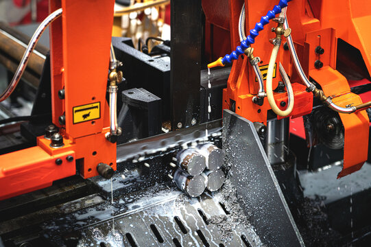 Industrial metal bar cutting process By CNC machinery with high precision electric saws and coolants.