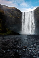 Tall waterfall in southern Iceland with mist and rocks