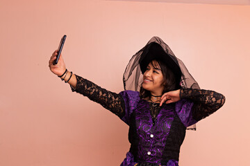 A woman dressed in a witch costume taking a selfie