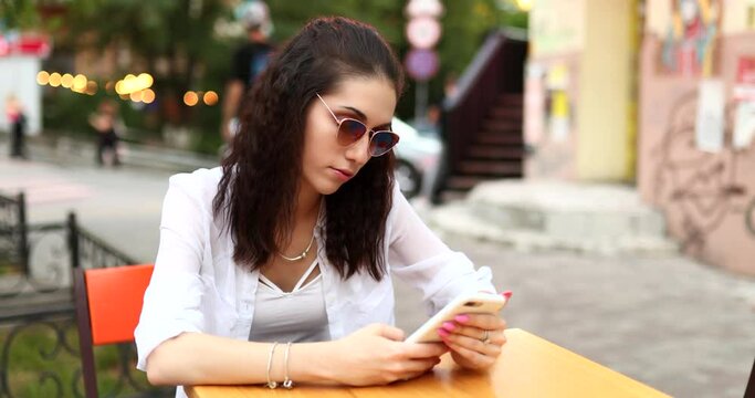 Young woman with glasses uses the phone.