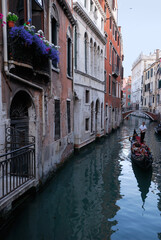 Fototapeta na wymiar Relaxing couple enjoying a gondola ride in a canal in Venice