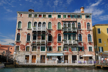 Naklejka premium Peeling red stucco on a Venetian building at San Basilio waterbus stop