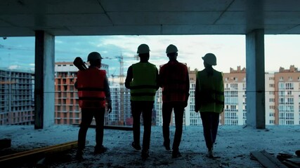 View of shot back builders engineers workers in hard hat team walking on construction at sunlight survey urban meeting skyscraper builder architect contractor inspector construction helmet slow motion