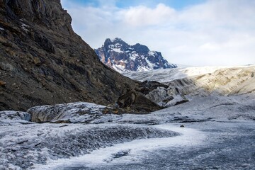 Fototapeta na wymiar Ice path towards mountains in a glacier in Iceland with blue skies and clouds