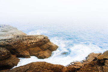 rocks, waves and fog on the cliff