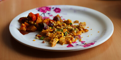 scrambled egg omlette and mixed vegetable served on a plate. Indian home made dish. side view
