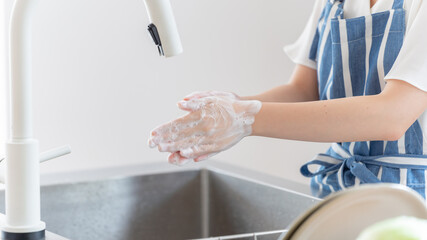 キッチンで手洗いをする女性