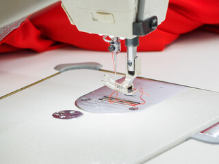 Close up of sewing process on the overlock in the sewing shop. Tailoring industry.. interior of garment factory shop. Closes making atelier with sewing machines.