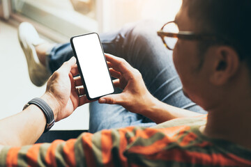 cell phone mockup blank white screen.man hand holding texting using mobile on desk at coffee shop.background empty space for advertise.work people contact marketing business,technology
