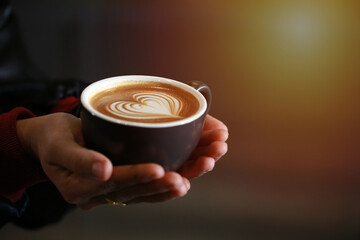 Close up hand serving hot coffee up with beautiful latte art