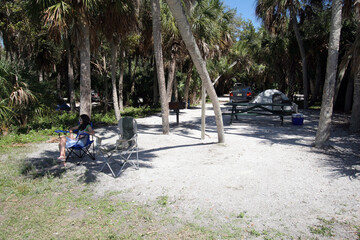 Young girl enjoying tent camping environment n Fort De Soto Park in Pinellas County, Florida.