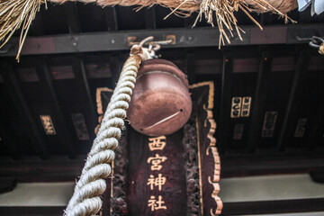 Worm's eye view of the bell at Nishinomiya shinto Shrine in Nagano. The wooden board reads "Nishinomiya Shrine"