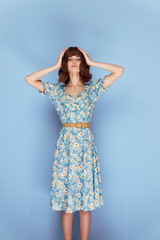 Naklejka premium Woman in dress Keeps his hands on his head looking forward fashionable hairstyle 