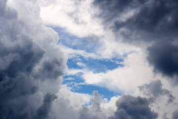 A hole in the stormy clouds revealing the blue sky in the background