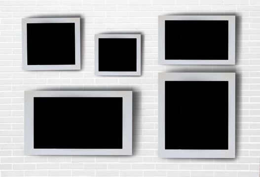 White picture frames arranged in a pattern on the wall. There is space for images or advertising materials.
