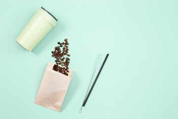Reusable eco coffee cup, roasted coffee beans and metal drinking straw. Zero waste concept