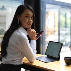 Fototapeta premium Portrait of female worker looking into camera while working in cafe