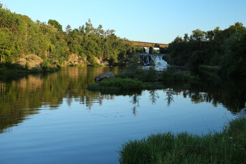 Fototapeta na wymiar Petite chute de la Petite Rivière-du-Loup à Rivière du Loup avec pont de train au parc des chutes.