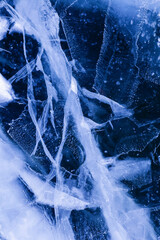 Detailed macro photo of Cracks and frozen bubbles on ice of deep lake in winter. Nature background.