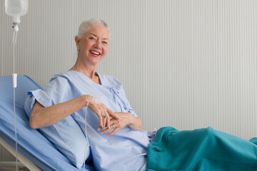 Elderly female patient lying on the bed in the hospital ward.