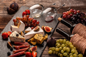 Cheese and cured meat prosciutto with fresh fig, grapes, strawberries and wine, Delicious appetizer, ideal as an aperitif
