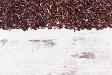 Heap of black rice on rustic board, healthy nutrition concept, copy space for text