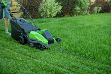 Fototapeta na wymiar Lawn mower on a green lawn.