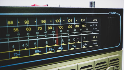 Black dial and red arrow of a portable radio close-up.
