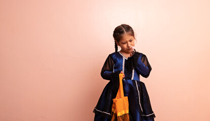 little girl dressed as a witch holding a candy