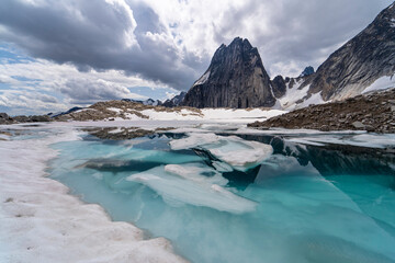 Glacier lake with snow leading towards tall mountain in Bugaboos provincial park with cloudy sky...