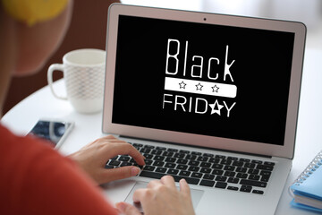 Young woman using laptop for online shopping at home. Black Friday sale