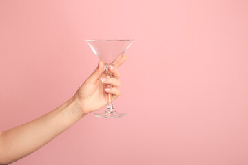 Hand with empty glass on color background