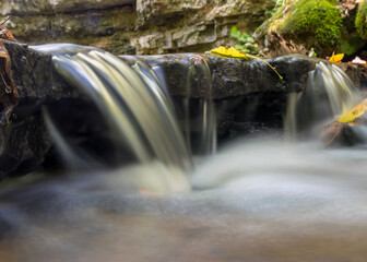a small rapid river flows through dolomite rocks, long-term exposure, gentle and fuzzy river water,...