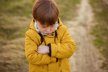 Portrait of an offended child boy in the autumn park