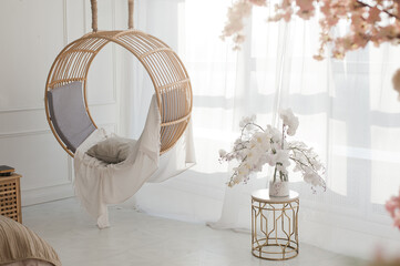 white interior with round swing and white orchid