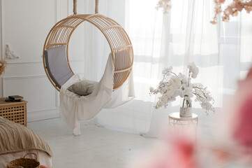 white interior with round swing and white orchid